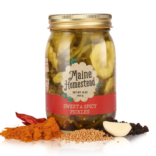 Jar of Maine Homestead sweet & spicy pickles with spices on a white background