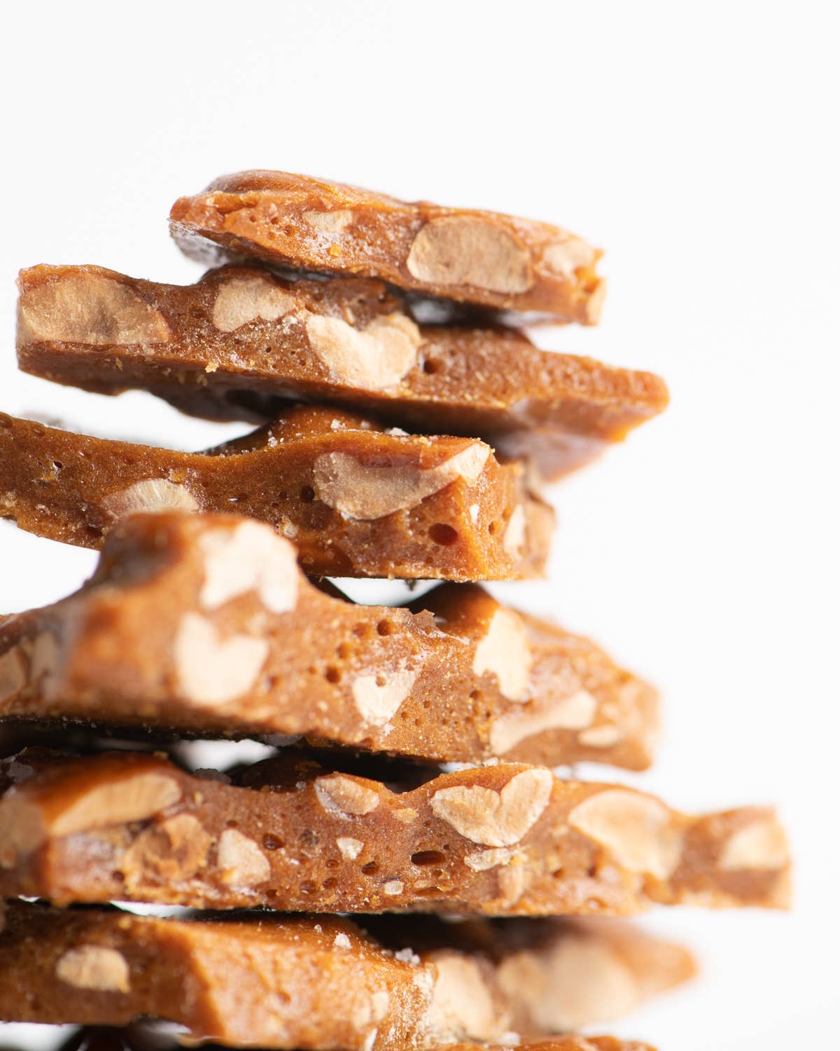 Stack of almond brittle on a white background