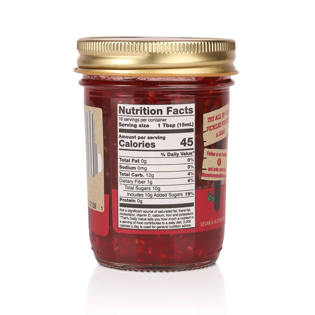 Jar of red jelly with gold lid and nutrition label on a white background
