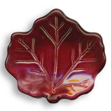 A leaf-shaped ceramic dish with a glossy, iridescent reddish-brown glaze and raised leaf vein details, shown on a white background.