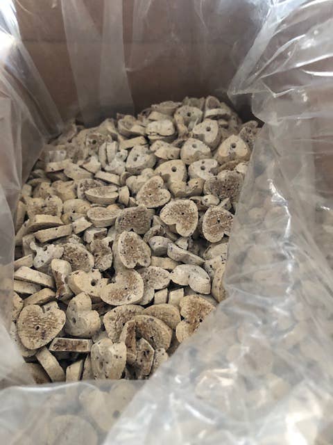 A bulk bag of dried, sliced herbal or veterinary supplements, showing round, porous beige and off-white slices inside a clear plastic bag.