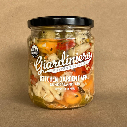 Jar of Giardiniera pickled vegetables on a brown background