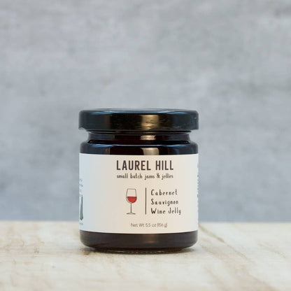 Jar of Laurel Hill Cabernet Sauvignon wine jelly on a marble surface with a gray background
