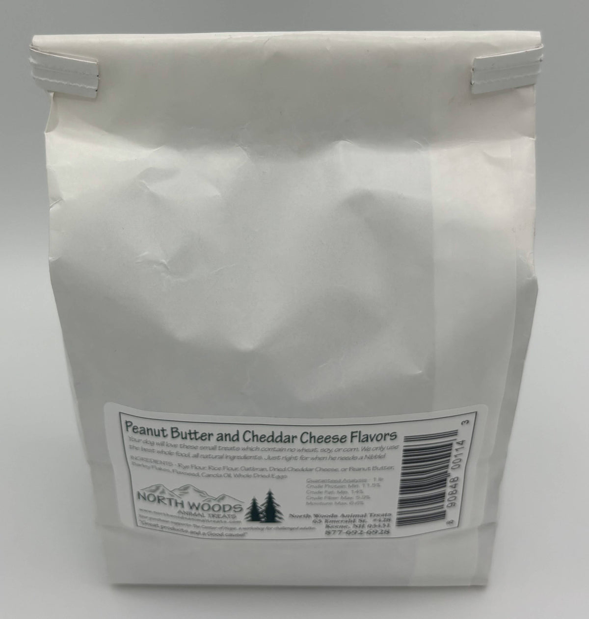 A white paper bag of North Woods Family Restaurant Peanut Butter and Cheddar Cheese Flavors, shown against a neutral gray background.