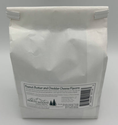 A white paper bag of North Woods Family Restaurant Peanut Butter and Cheddar Cheese Flavors, shown against a neutral gray background.