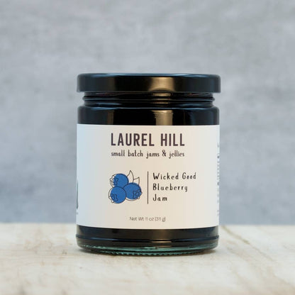 Jar of Laurel Hill Wicked Good Blueberry Jam on a marble surface with a gray background