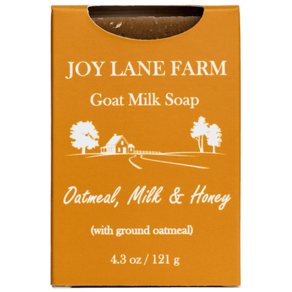 A rectangular orange box of Joy Lane Farm Goat Milk Soap, featuring white text and a white line drawing of a farm scene. The box indicates the scent is Oatmeal, Milk & Honey (with ground oatmeal) and shows a size of 4.