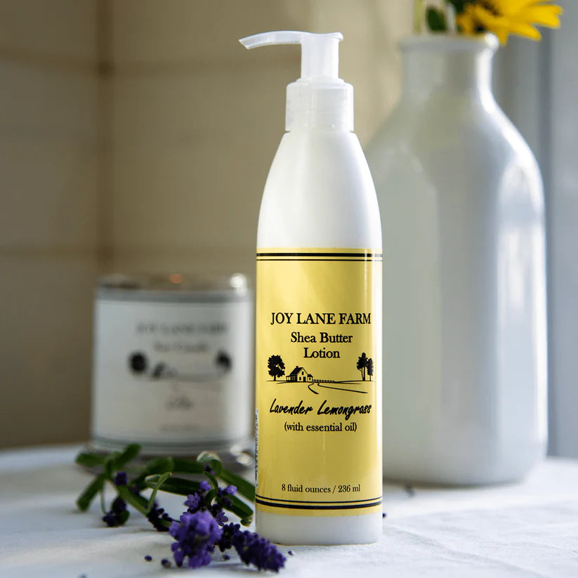 Shea butter lotion bottle with lavender and lemongrass scent on a surface with decorative elements.