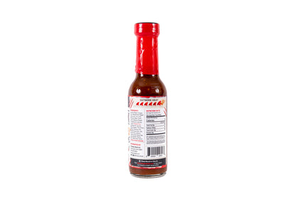 A bottle of hot sauce shown from the back, featuring a red cap, dark reddish-brown sauce inside, and a white label with red and black text.