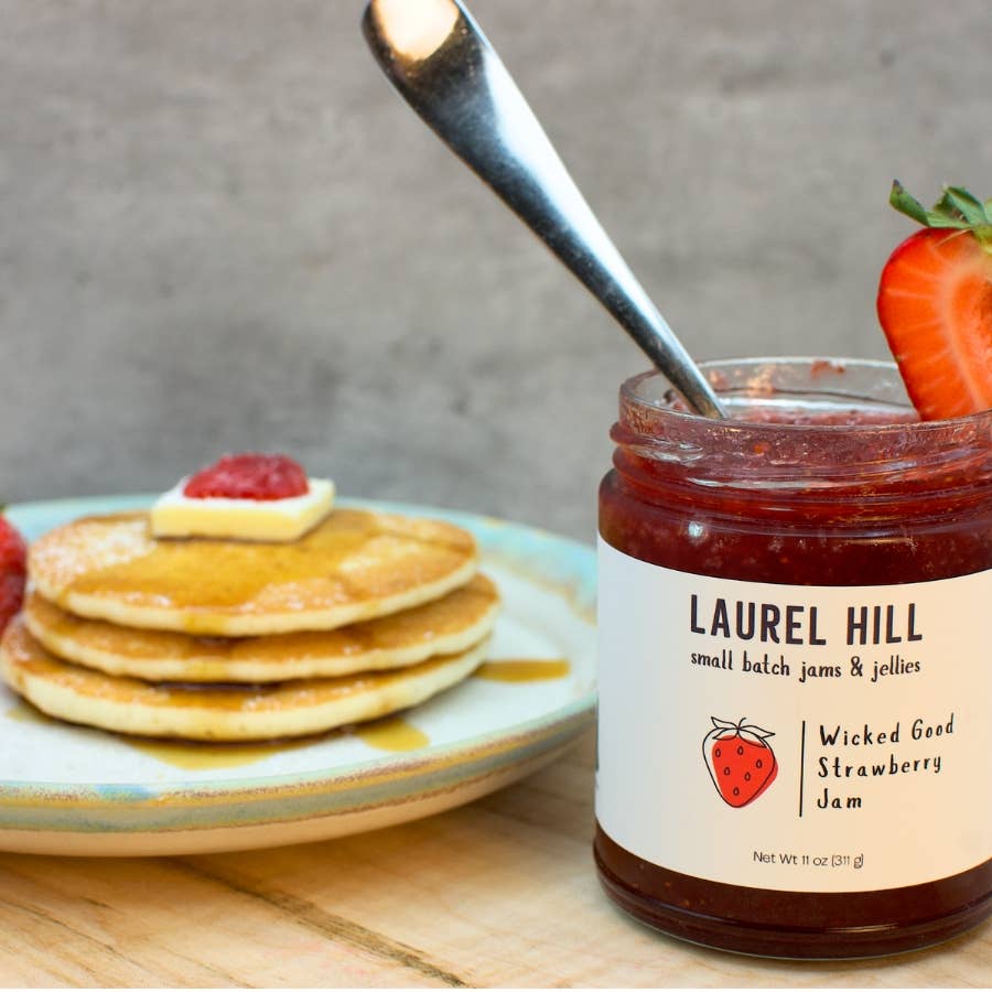 Jar of Laurel Hill strawberry jam with pancakes on a plate