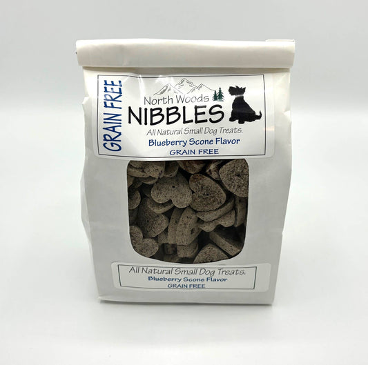 A bag of North Woods Nibbles Blueberry Scone Flavor grain free all natural small dog treats, shown against a plain white background.