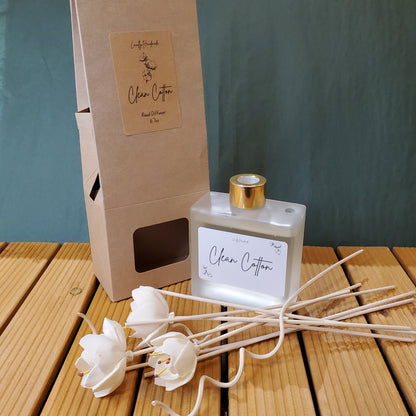 Perfume bottle with floral diffuser on a wooden surface