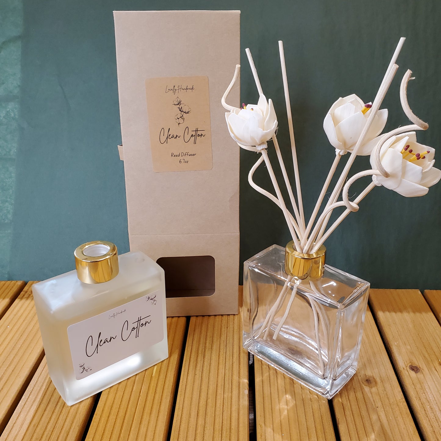 Two perfume bottles with gold caps and white flower designs on a wooden surface.