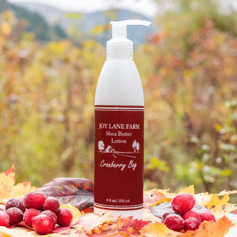 Shea butter lotion bottle with pump on a background of autumn leaves and berries
