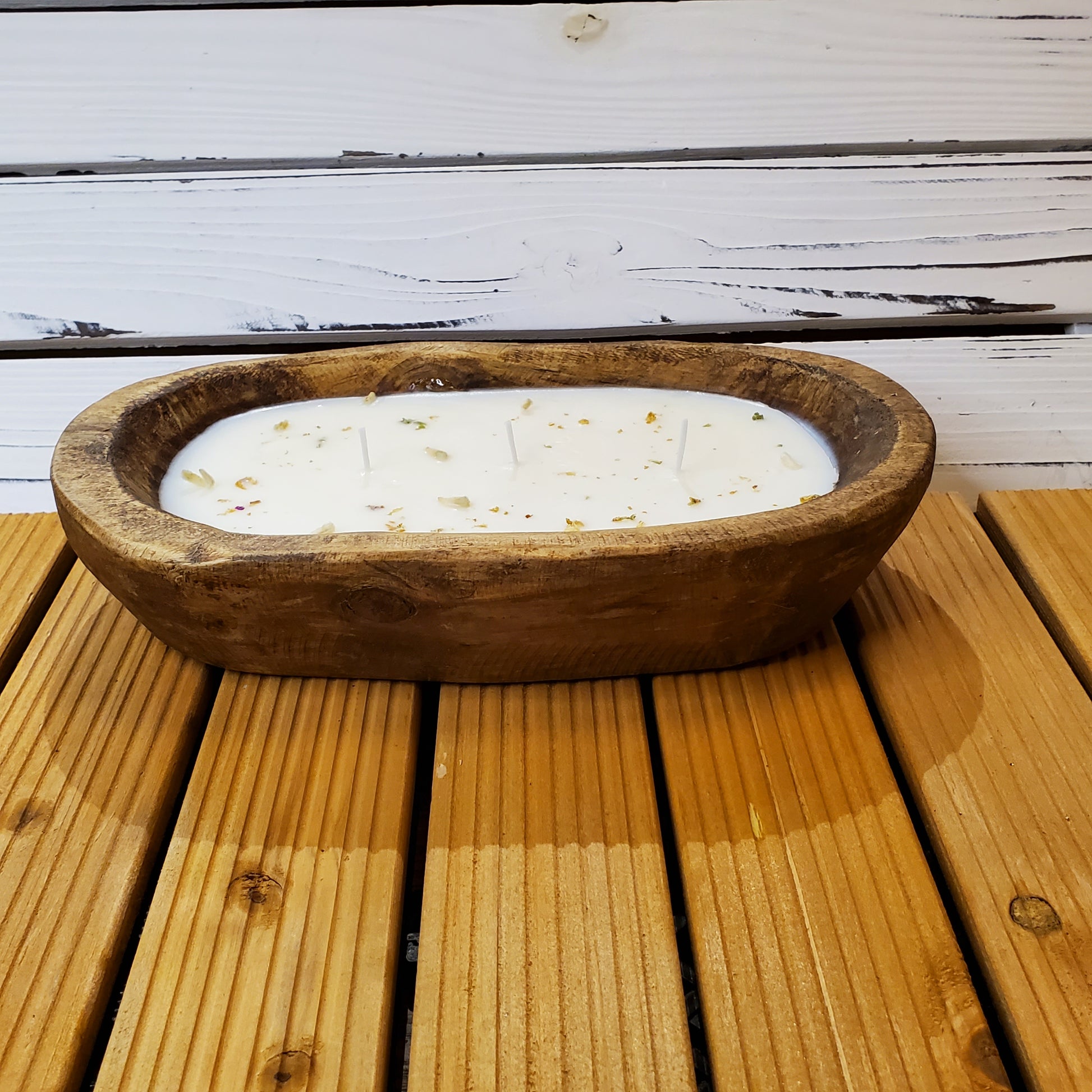 Wooden bowl with a candle on a wooden surface