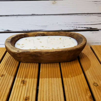 Wooden bowl with a candle on a wooden surface