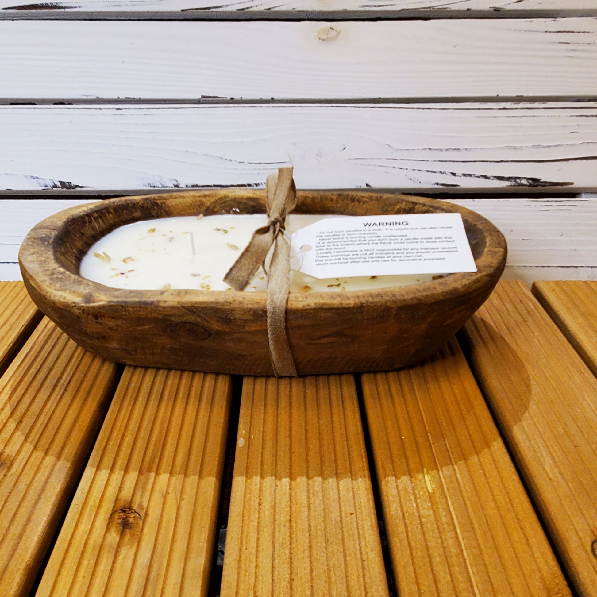 Wooden bowl with a candle on a wooden surface