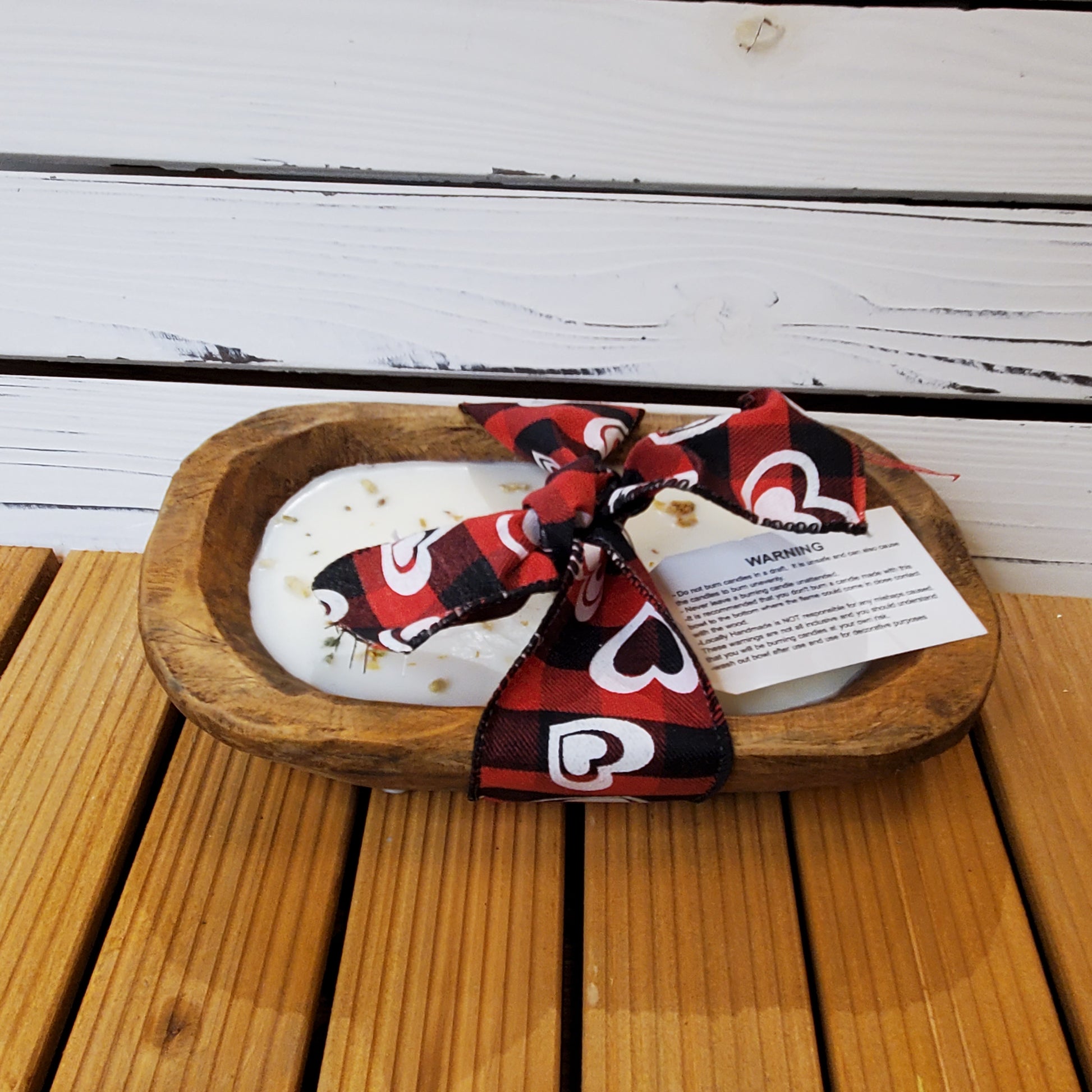 Decorative stone with a red and black checkered ribbon on a wooden surface