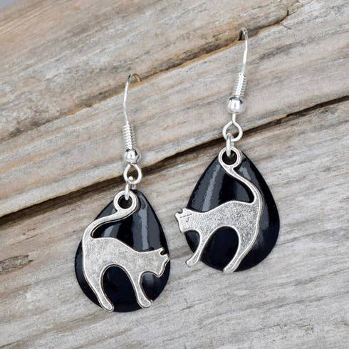 Black and silver cat-shaped earrings on a wooden surface