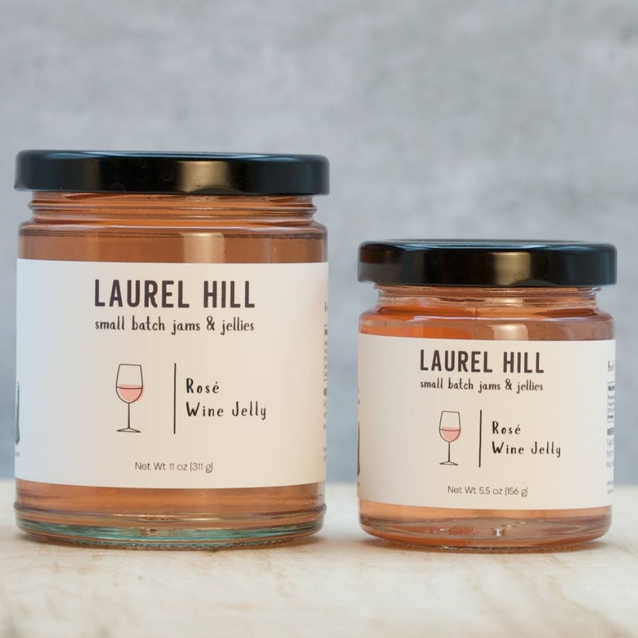 Two jars of Laurel Hill Rose Wine Jelly on a marble surface with a gray background