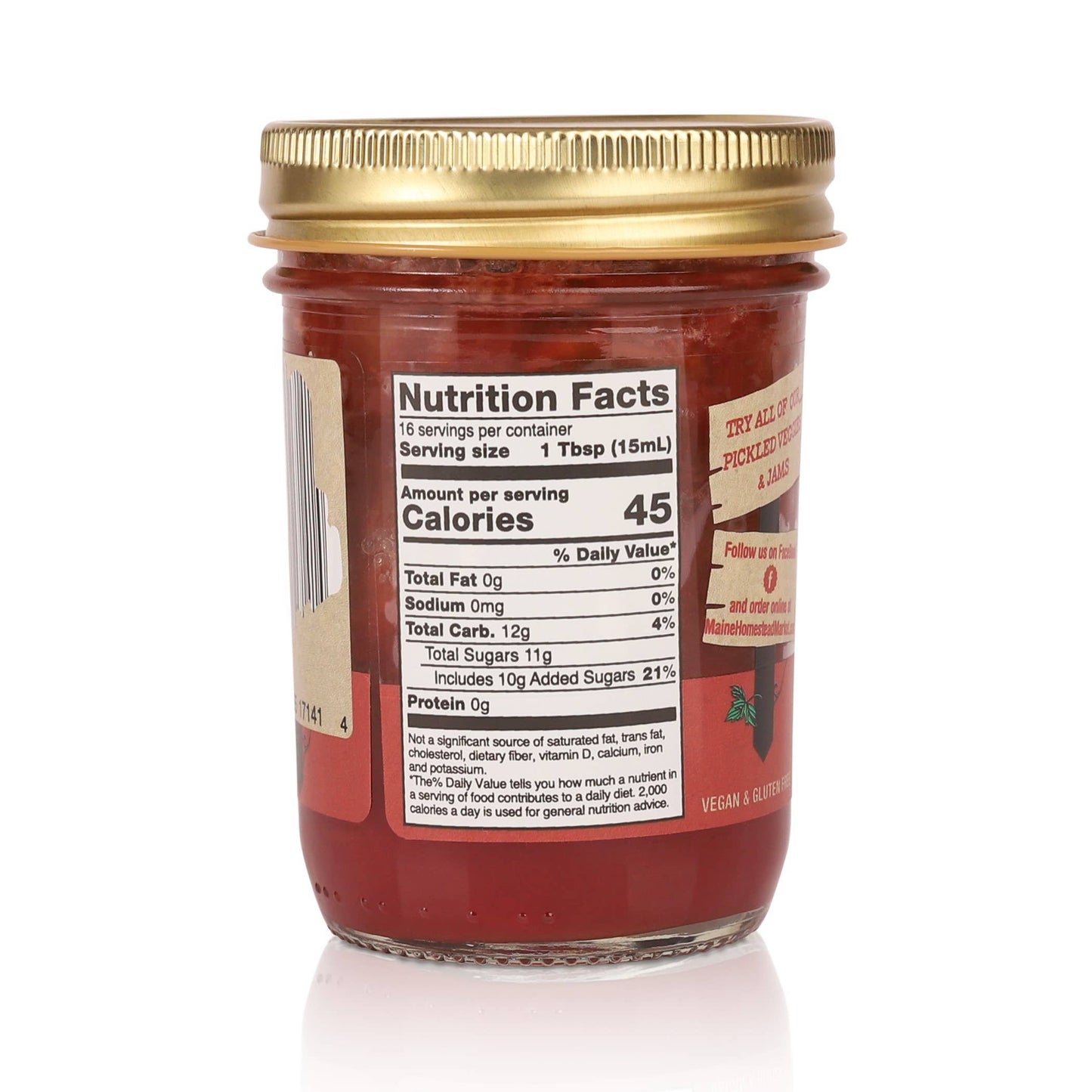 Jar of red jelly with gold lid and nutrition label on a white background
