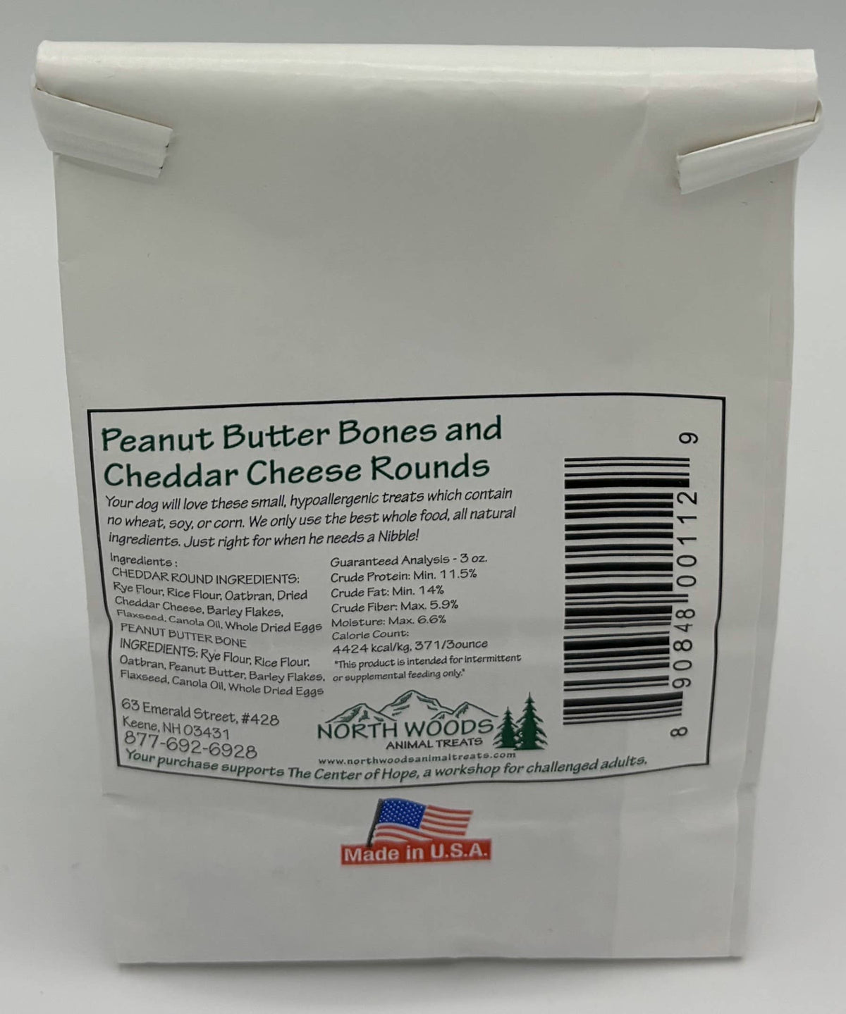A white plastic bag of North Woods Peanut Butter Bones and Cheddar Cheese Rounds, showing the front label with product details, a barcode, and a small red 'Made in U.S.