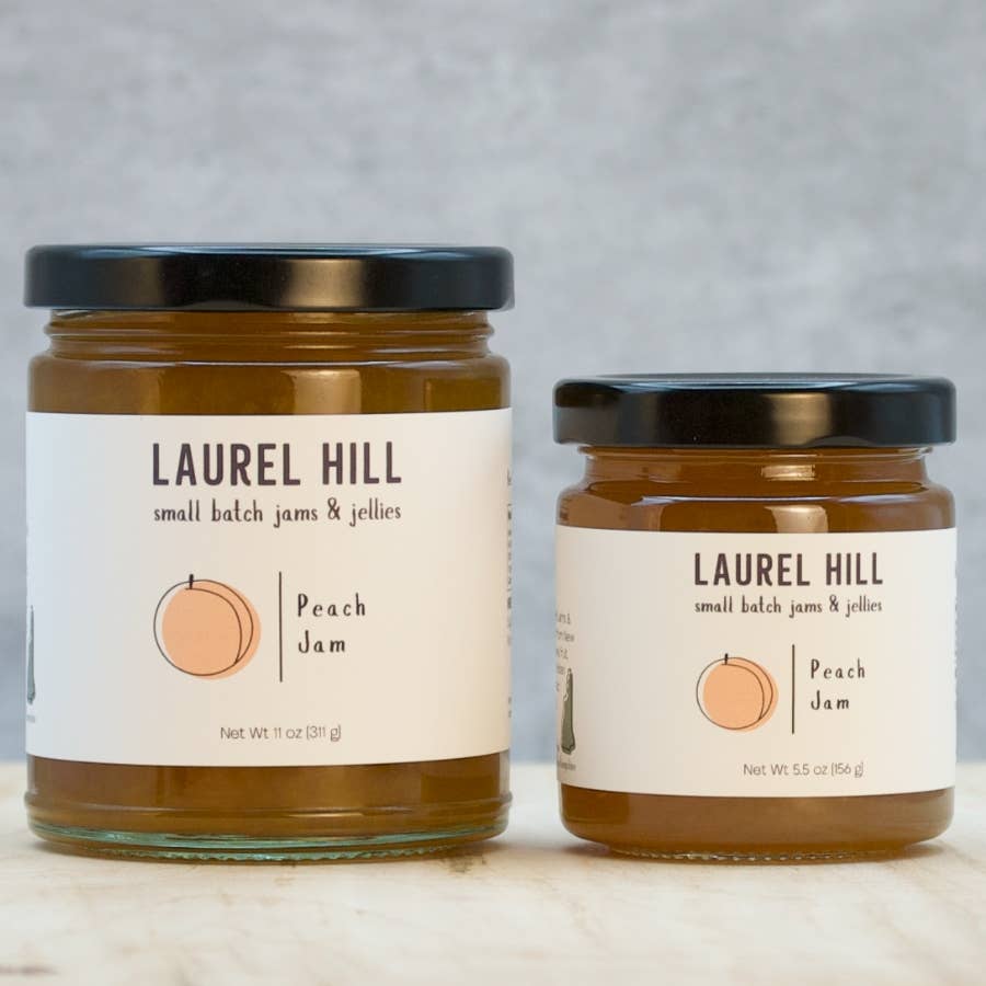 Two jars of Laurel Hill peach jam on a neutral background