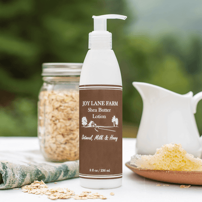 Joy Lane Farm shea butter lotion bottle with oats and a jar in the background