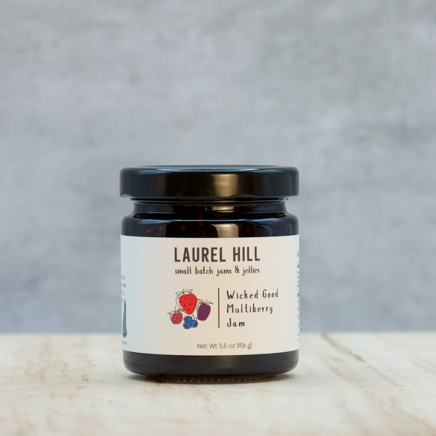 Jar of Laurel Hill Wicked Good Mulberry Jam on a wooden surface with a gray background