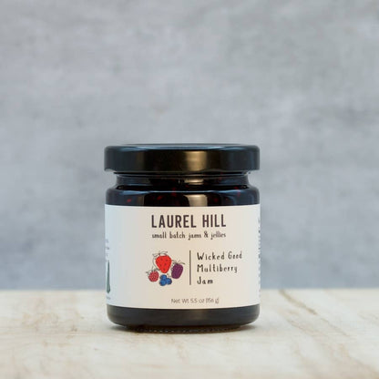 Jar of Laurel Hill Wicked Good Mulberry Jam on a wooden surface with a gray background