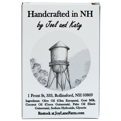 Front-facing product box with the text 'Handcrafted in NH by Joel and Katy' and a grayscale water tower illustration. The box also includes the address '1 Front St, 333, Rollinsford, NH 03869' and ingredients listed at the bottom, plus 'Restock at JoyLaneFarm.