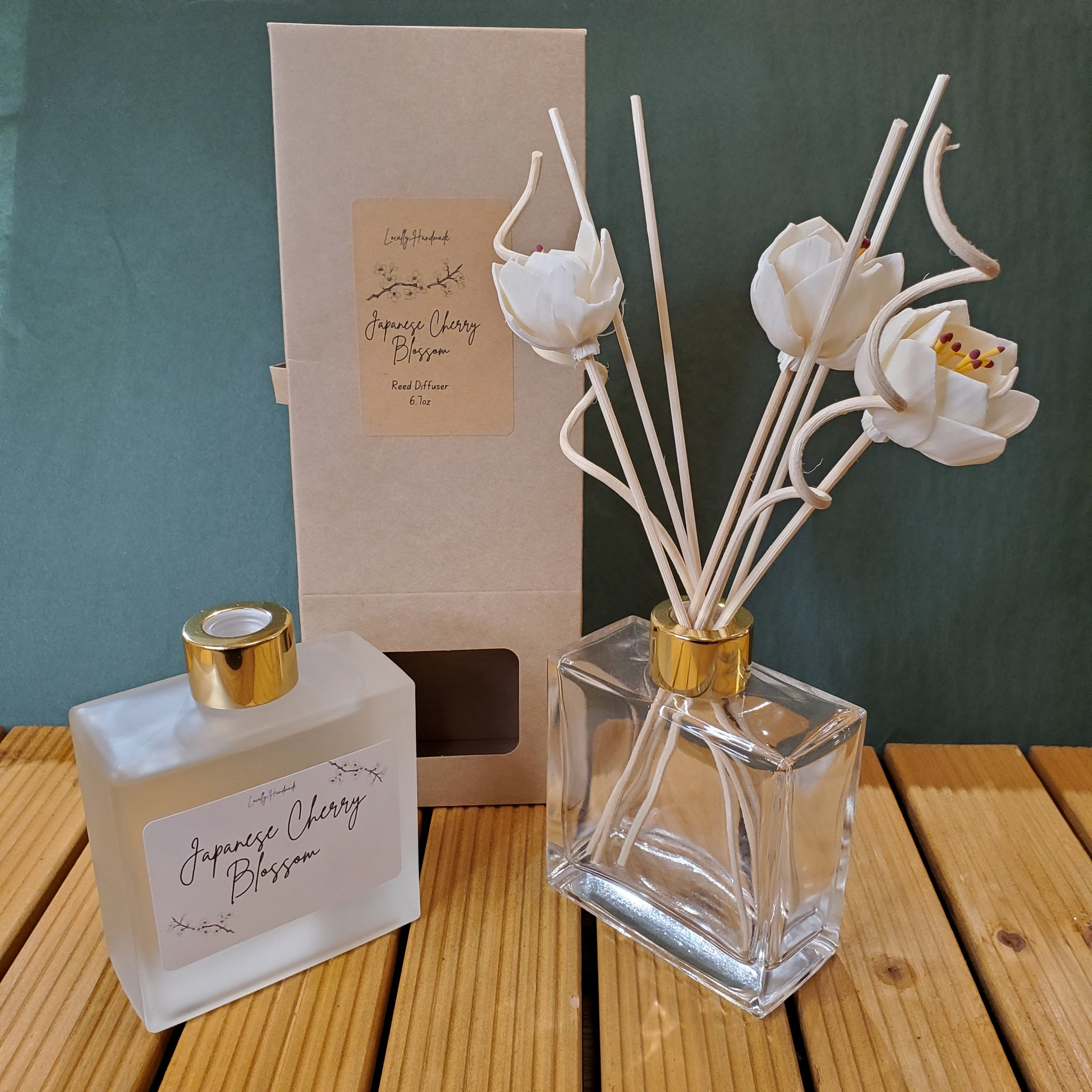 Perfume bottle with floral diffuser sticks on a wooden surface