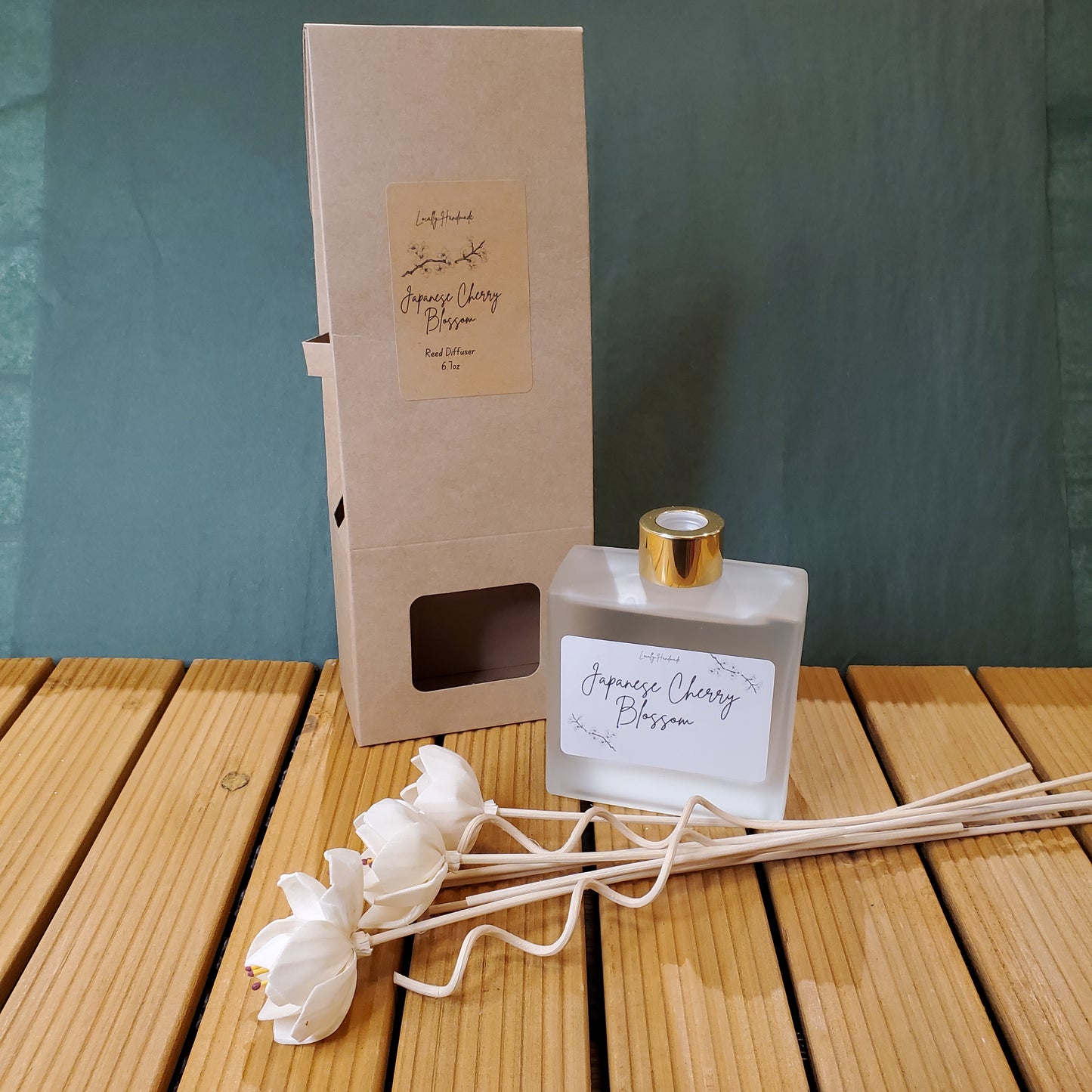 Diffuser bottle with reeds and packaging on a wooden surface