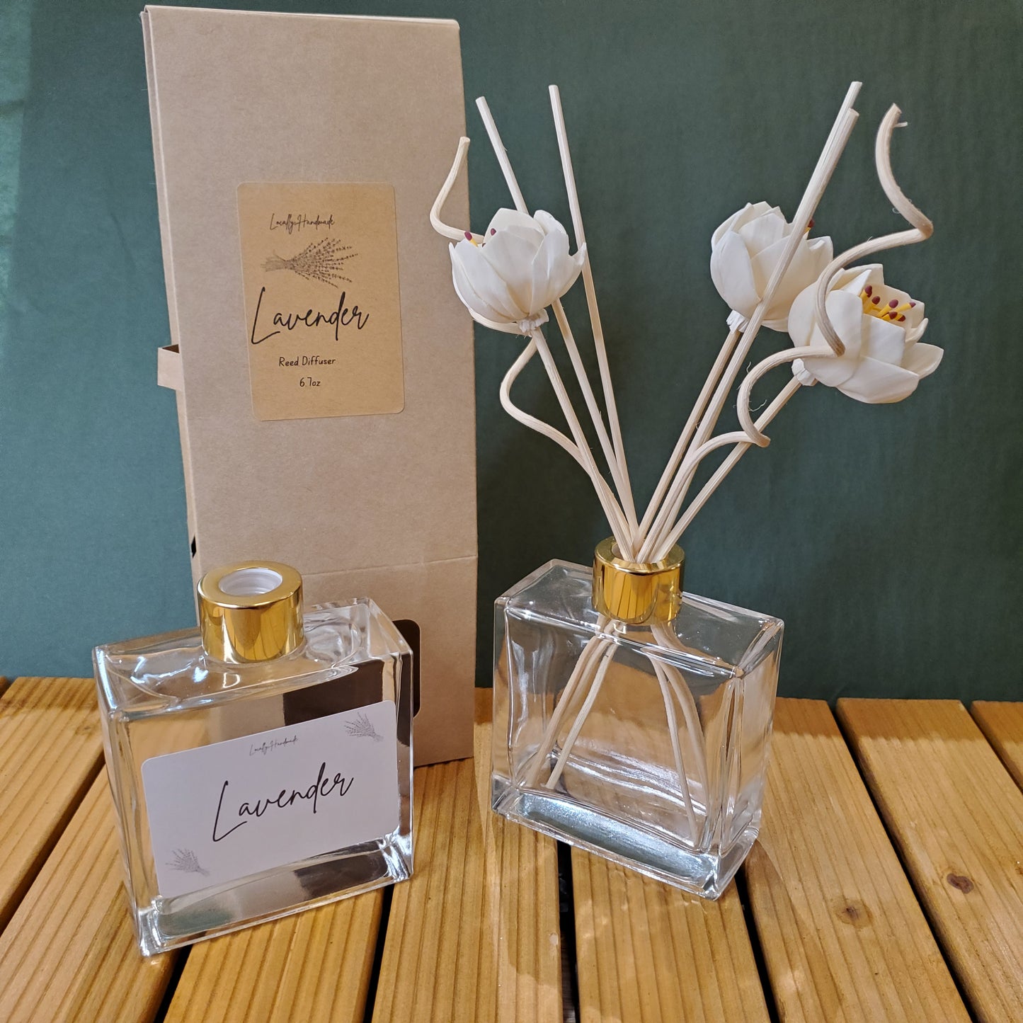 Perfume bottle with floral diffuser on a wooden surface
