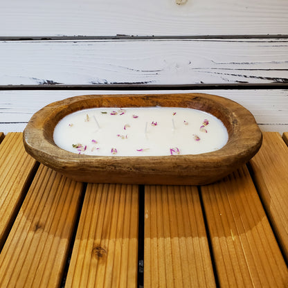 Wooden bowl with a candle inside on a wooden surface