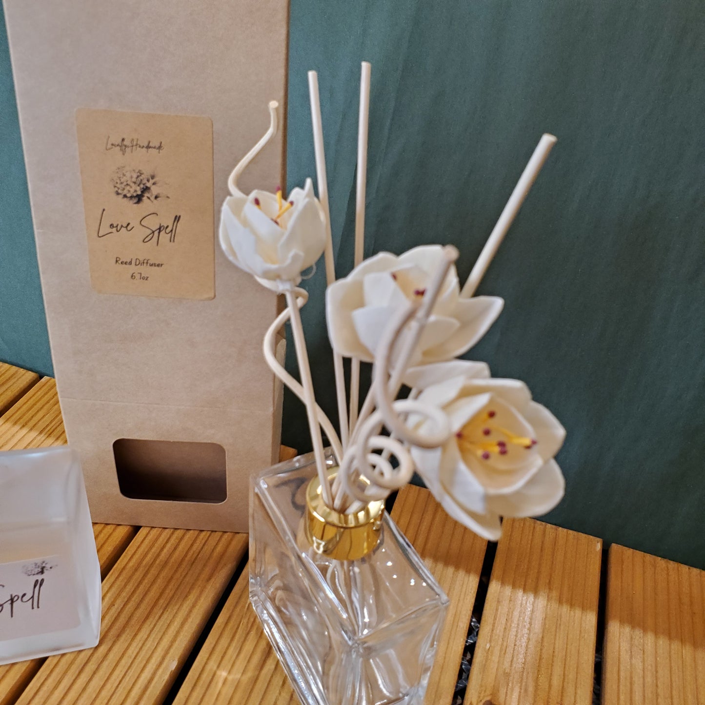 Decorative diffuser with white flowers on a wooden surface