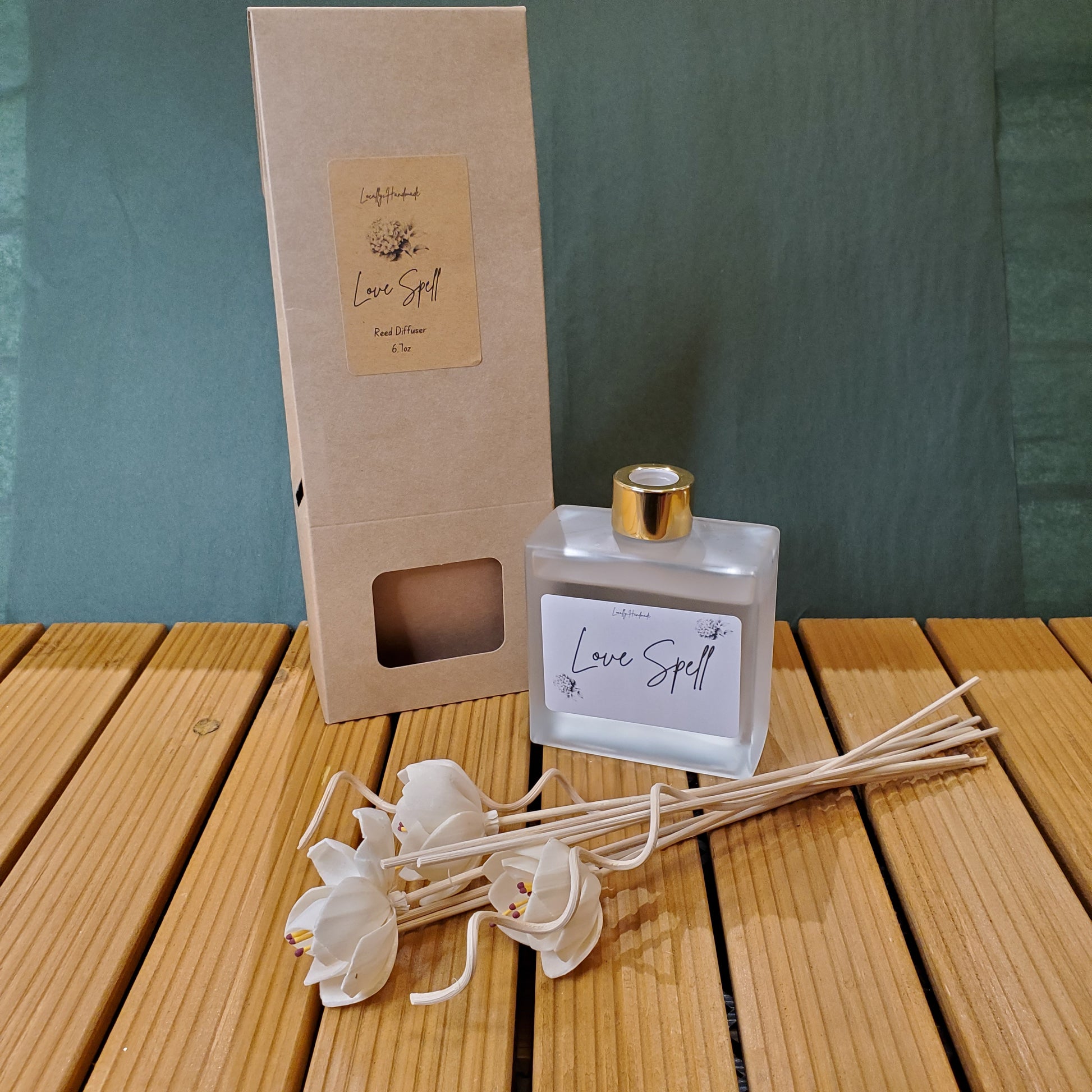 Diffuser bottle with reeds and packaging on a wooden surface