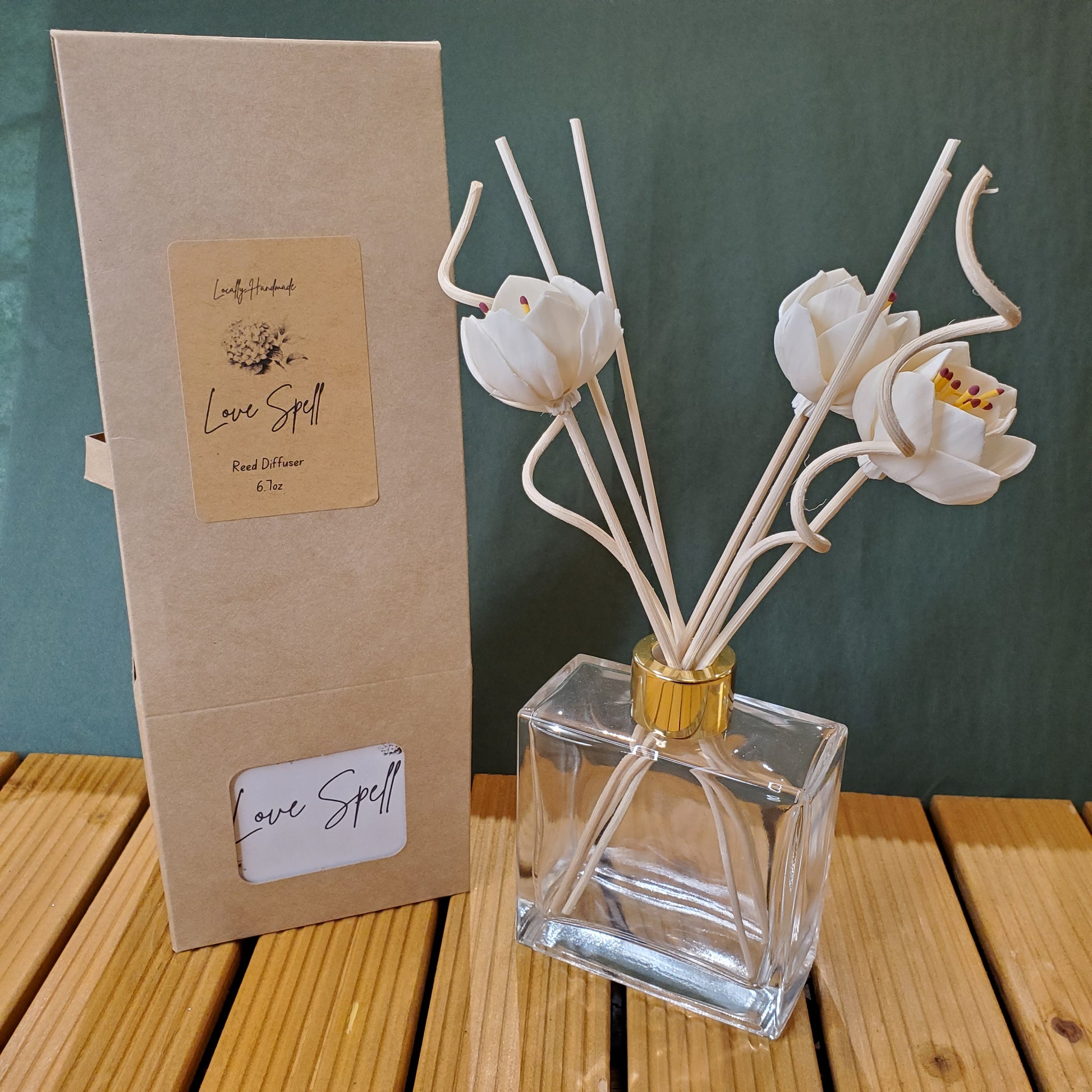 Clear glass bottle with white floral elements on a green surface