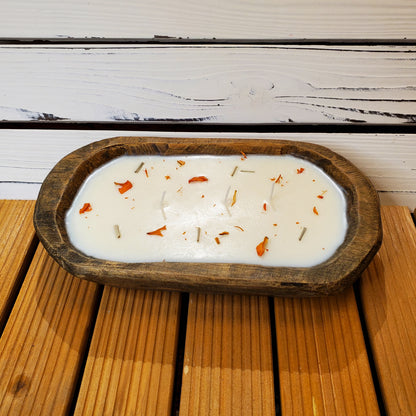 Candle in a wooden holder with decorative elements on a wooden surface