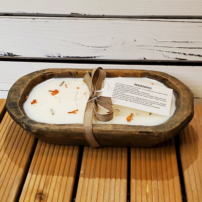 Wooden bowl with a candle and a warning label on a wooden surface