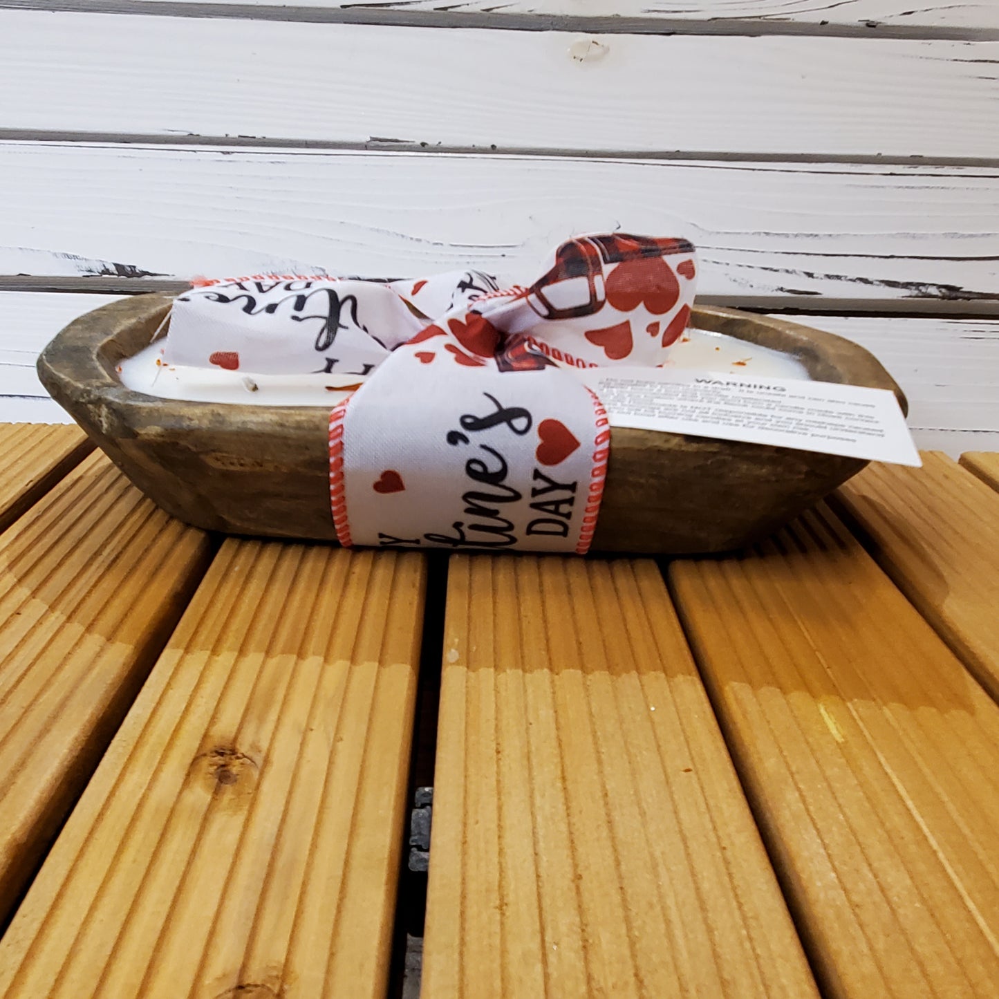 Wooden bowl with a Valentine's Day-themed ribbon on a wooden surface