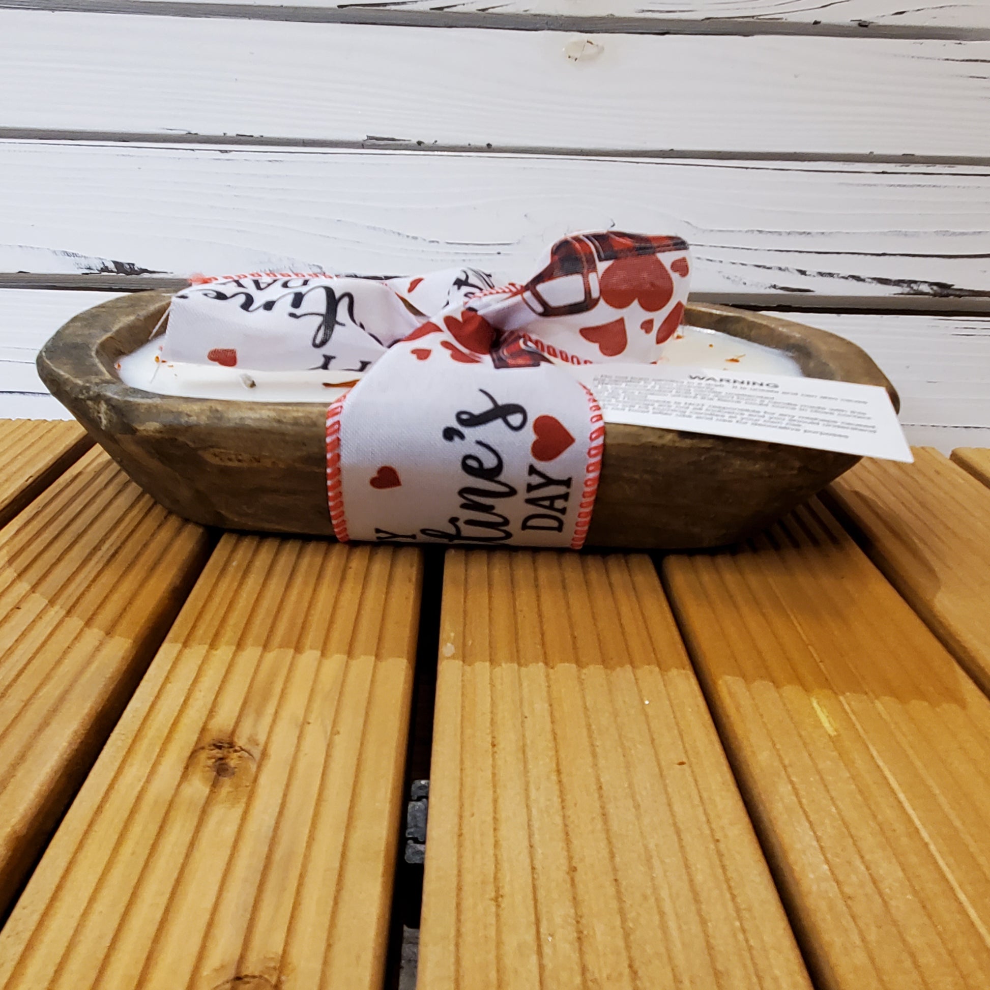 Wooden bowl with a Valentine's Day-themed ribbon on a wooden surface