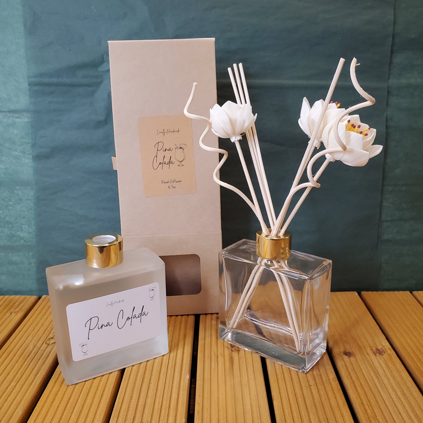 Perfume bottle with floral design and decorative box on a wooden surface