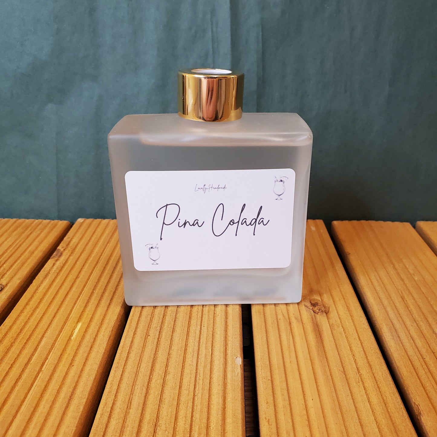 Perfume bottle with a gold cap on a wooden surface