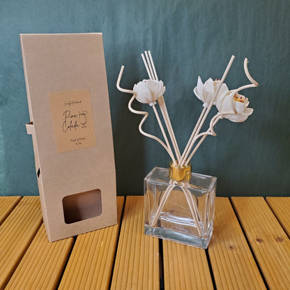 Decorative metal flower arrangement with a clear glass vase on a textured surface.