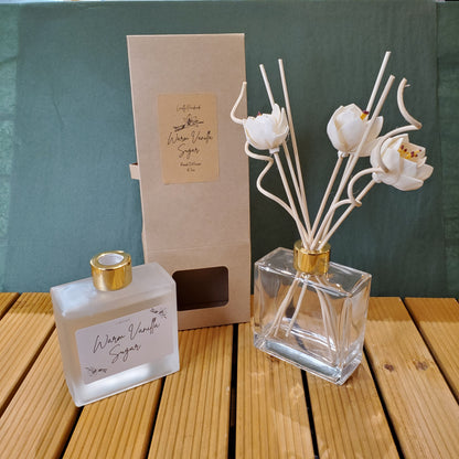 Perfume bottle with floral design on a green and wooden surface