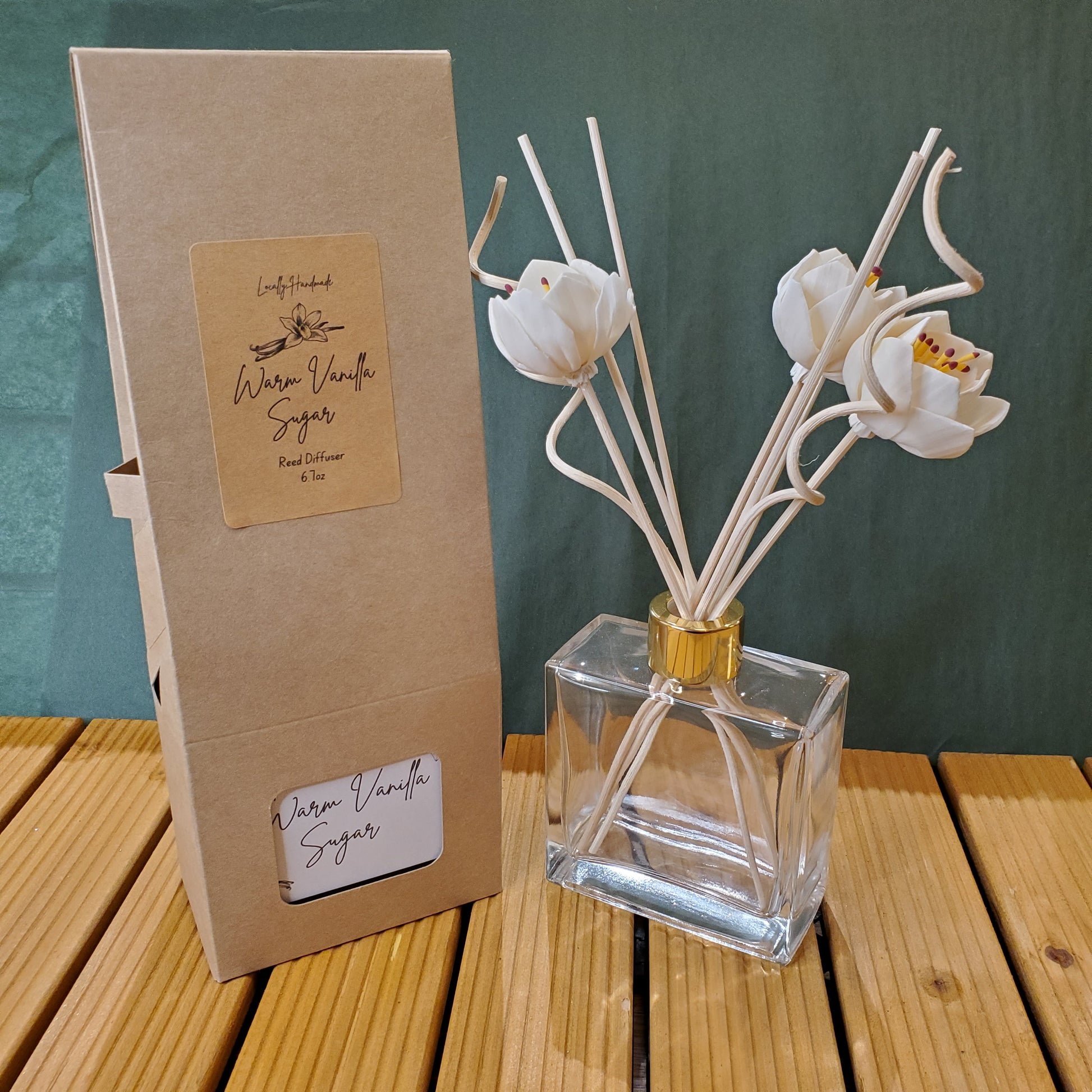 Decorative flower-shaped candle holder with a clear glass container on a green surface.