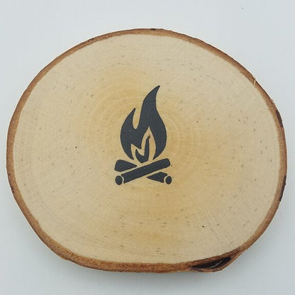 A round coaster made from birch tree wood with a hand-painted campfire design in the center.