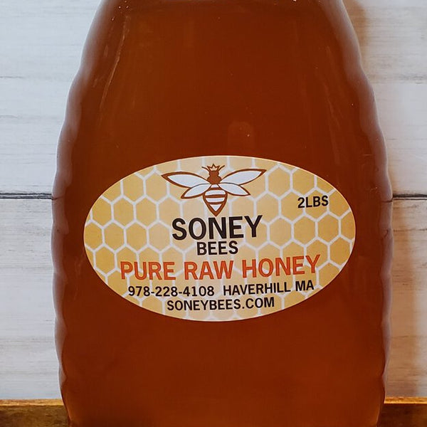 Honey container with a label on a wooden surface